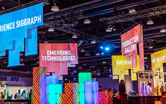 "Experience SIGGRAPH," "Emerging Technologies," "Production Gallery," "The Studio," and "Art Gallery" banners hanging from the ceiling.