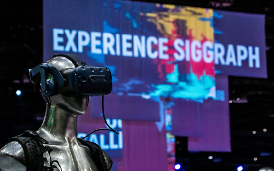 Mannequin wearing a VR headset in the foreground with an Experience SIGGRAPH sign in the background.