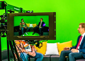 Two SIGGRAPH attendees on camera in a green room.